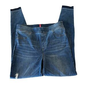 Spanx Distressed Skinny Jegging in a medium wash blue with a raw hem.